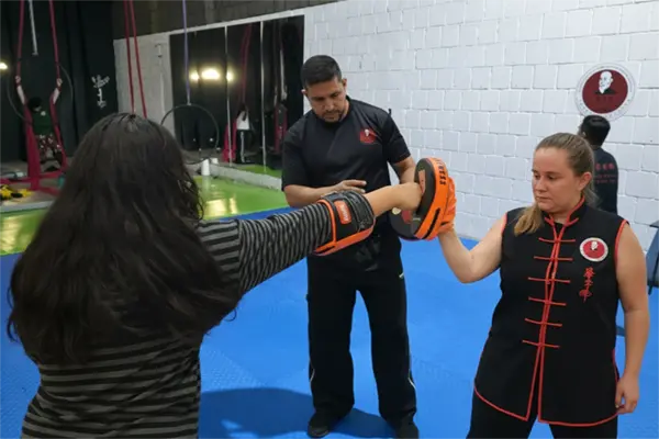 Instructor de Kung Fu enseñando técnicas de golpeo (distancia larga) en un ambiente seguro